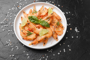 Shrimp with herbs and coarse salt on black surface for cooking background or seafood concept