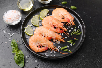 Shrimp served with rosemary, salt and olives on black plate for gourmet appetizer or restaurant...