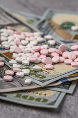 Dollar bill and a set of medicine pills. Rising costs of medical care. Reliefs for buying medicine.Pills in capsules scattered on US dollars currency.Concept of health care in USA.