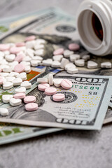 Dollar bill and a set of medicine pills. Rising costs of medical care. Reliefs for buying medicine.Pills in capsules scattered on US dollars currency.Concept of health care in USA.