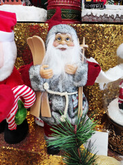 A Christmas toy in the form of Santa Claus with a white beard and glasses, wearing a hat and coat.  The atmosphere of celebration, comfort and winter fun. A holiday card for the New Year holiday.