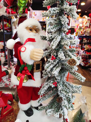 A Christmas toy in the form of Santa Claus with a white beard and glasses, wearing a hat and coat.  The atmosphere of celebration, comfort and winter fun. A holiday card for the New Year holiday.