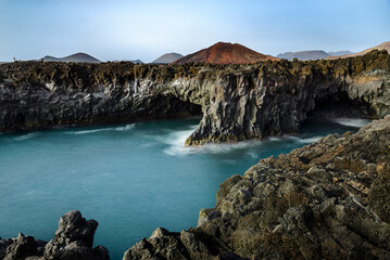 Fototapeta premium Turquoise water crashing against volcanic cliffs in los hervideros, lanzarote