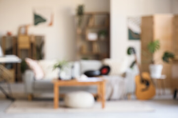 Blurred view of living room with sofa, table and musical instruments