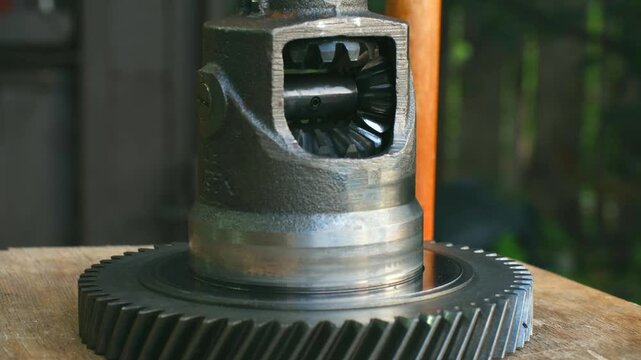 Precision automotive engineering, pinion gear rotating and smoothly meshing with crown wheel inside car differential, demonstrating intricate power transmission mechanism