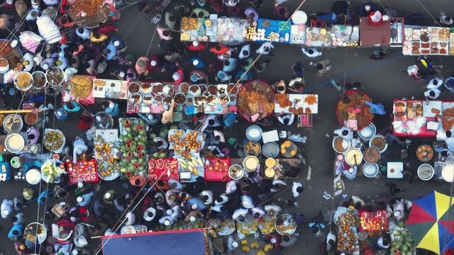 Dhaka, Bangladesh - 23 August 2025: Aerial view of a bustling street market filled with vendors and customers, showcasing a vibrant array of colors and textures.