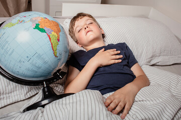 A young boy peacefully sleeping in bed while holding a globe, symbolizing childhood dreams, travel, geography, education, global unity, future exploration, and connection with the world.
