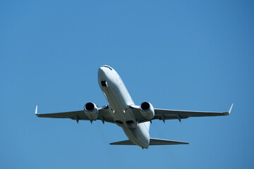 Airplane in the blue sky, close-up view of the plane. Aircraft soaring through the clear sky, detailed view of the plane.