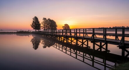 Picturesque morning landscape with wooden bridge over lake and sunrise view