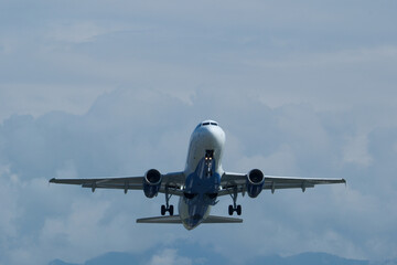 Airplane in the cloudy sky. The plane gaining altitude after takeoff from the airport.
