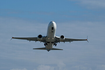 Airplane in the cloudy sky. The plane gaining altitude after takeoff from the airport.