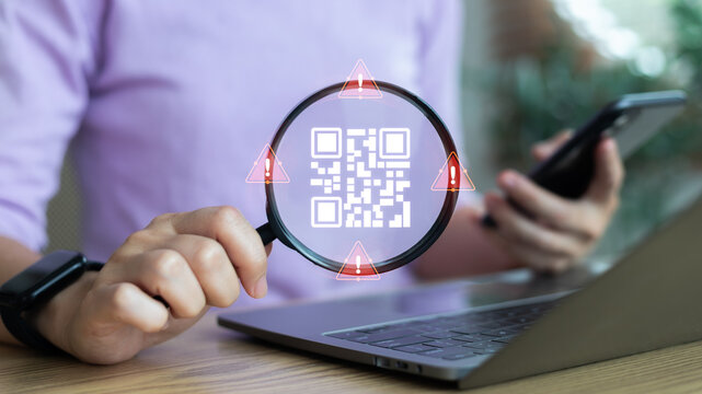 Close-up hand holding a magnifying glass scanning a QR code with warning alert icons. Concept of QR code scam, fraud detection, online phishing, cybersecurity, mobile payment risk, and digital safety.