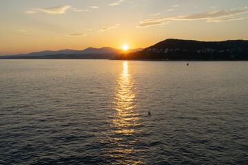 A breathtaking golden sunset over the Mediterranean Sea, with a stunning view of the Nice coastline from Saint-Jean-Cap-Ferrat, France.