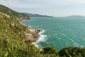 View from the hiking path to Lagoinha do Leste beach via Matadeiro. Cliffs, forest and atlantic ocean. Florianopolis, Brazil