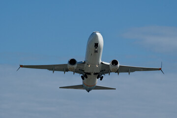 Airplane in the cloudy sky. The plane gaining altitude after takeoff from the airport.