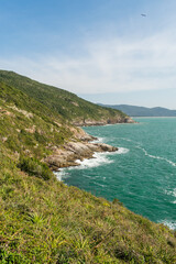 Fototapeta premium View from the hiking path to Lagoinha do Leste beach via Matadeiro. Cliffs, forest and atlantic ocean. Florianopolis, Brazil