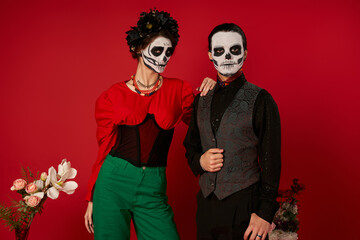 Couple enjoying heritage with bright colors and sugar skull designs for Dia de los Muertos