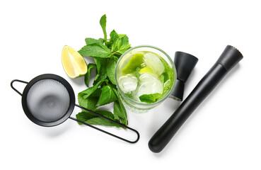 Glass of fresh Mojito cocktail with mint and bar tools on white background