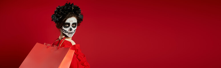 Woman celebrates day of the dead with sugar skull face paint and festive attire in colors