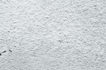 Rough white wall surface with fine cracks and textured bumps close up