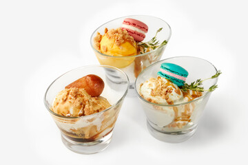 Ice cream dessert variations with macarons and toppings in glass bowls