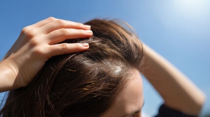 Naklejka premium Close up view of person scalp under bright sunlight, showcasing healthy hair and hand gently touching hair. image conveys sense of care and attention to hair health