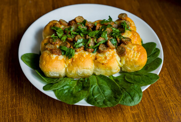 Close-up of Cumberland Sliced Sausages with Garlic and Cheddar Cheese Dough Balls Tear and Share Bread, Spinach and Parsley on Dark Wood