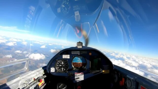 Soaring glider cockpit view with blue sky and fluffy white clouds