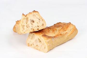 Baguette bread cut in half on a white background