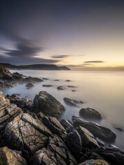 Obraz premium Scenic Coastal View at Sunset with Rocks and Tranquil Ocean