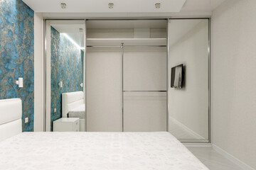 Modern Minimalist Bedroom with Mirrored Wardrobe and Blue Accent Wall