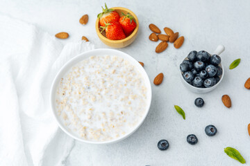Oatmeal porridge with blueberries, strawberries, almonds and milk