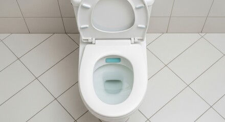 A clean white toilet is ready for use in a tiled bathroom