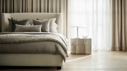 Fototapeta premium Elegant Scandinavian bedroom featuring a white bed with silver accents and cozy throw. Minimalist bedside table and metallic framed mirror reflect gentle daylight, concept of home decor