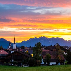 Fototapeta premium A picturesque village nestled at the foot of majestic mountains, bathed in the vibrant hues of a breathtaking sunset.