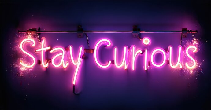 Bright pink neon sign displays Stay Curious. Dark background enhances glowing text. Simple message, inspirational vibe.