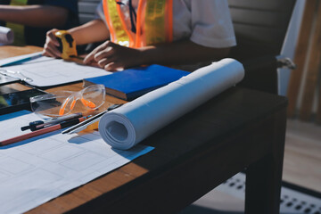 Closeup of team of industrial engineers meeting analyze machinery blueprints consult project on table in manufacturing factory. Working in manufacturing plant or production plant.