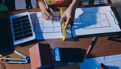 Closeup of team of industrial engineers meeting analyze machinery blueprints consult project on table in manufacturing factory. Working in manufacturing plant or production plant.