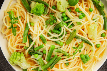 Spaghetti vegetables green peas, broccoli, string beans, kohlrabi vegetarian pasta tasty snack fresh delicious gourmet food background on the table rustic top view copy space vegan food
