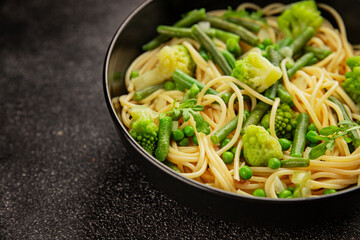 Spaghetti vegetables green peas, broccoli, string beans, kohlrabi vegetarian pasta tasty snack fresh delicious gourmet food background on the table rustic top view copy space vegan food