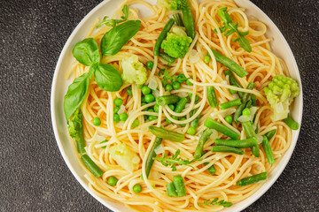 Spaghetti vegetables green peas, broccoli, string beans, kohlrabi vegetarian pasta tasty snack fresh delicious gourmet food background on the table rustic top view copy space vegan food
