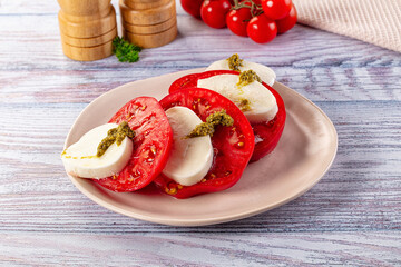 Italian Caprese salad with tomato, mozarella and pesto