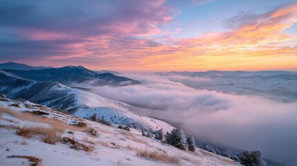 A vibrant sunrise paints the snowy mountain peaks as soft clouds gently fill the valleys below