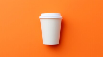 Disposable coffee cup on vibrant orange background, minimalistic design, perfect for branding or seasonal promotions.
