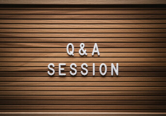White letters forming 'Q&A Session' on a board with a wooden background.	