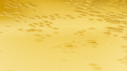 Golden plaster wall texture with subtle cracks and rough surface, elegant abstract background for luxury, festive, and decorative design.