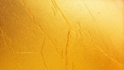 Golden plaster wall texture with subtle cracks and rough surface, elegant abstract background for luxury, festive, and decorative design.