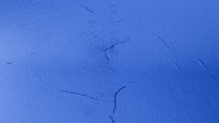 Blue plaster wall texture with subtle rough surface and gradient shades, abstract rustic background for design and decoration.