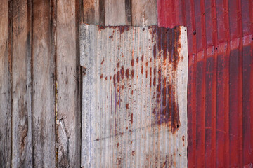 A rustic composition featuring weathered wooden planks and corrugated metal, presenting a juxtaposition of textures and tones. The scene evokes a sense of decay and enduring strength.