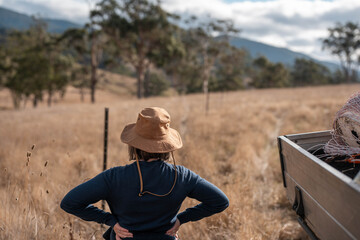 female farmer fencing on a farm reeling a electric fence a farm putting up a steel post fence with...